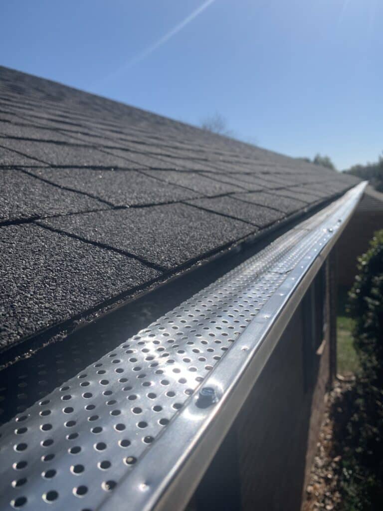 Roof of a house showing gutter and gutter guard protection against leaves Home maintenance